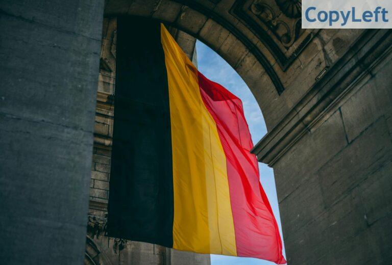 Vibrant Belgian flag under iconic archway in Brussels, symbolizing national pride.
